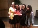 4 ladies from Pi Theta Epsilon holding trophy